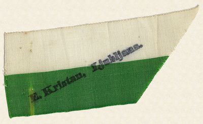 Razpoznavni trak Edvarda Kristana iz blaga v beli in zeleni barvi (barve mesta Ljubljane).