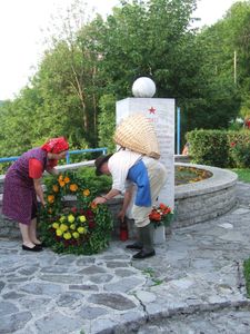 Rezijana (levo Luigia Negro) polagata venec, ki ga je cvetličarka izdelala danes, k spomeniku padlih borcev na Kambreškem (D898)