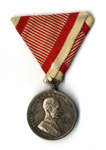 Tapferkeits Medaille - srebrna medalja za pogum. Na sprednji  strani je napis "FRANZ JOSEPH I V.G.G. KAISER V. OESTERREICH", na hrbtni pa "Der Tapferkeit".
